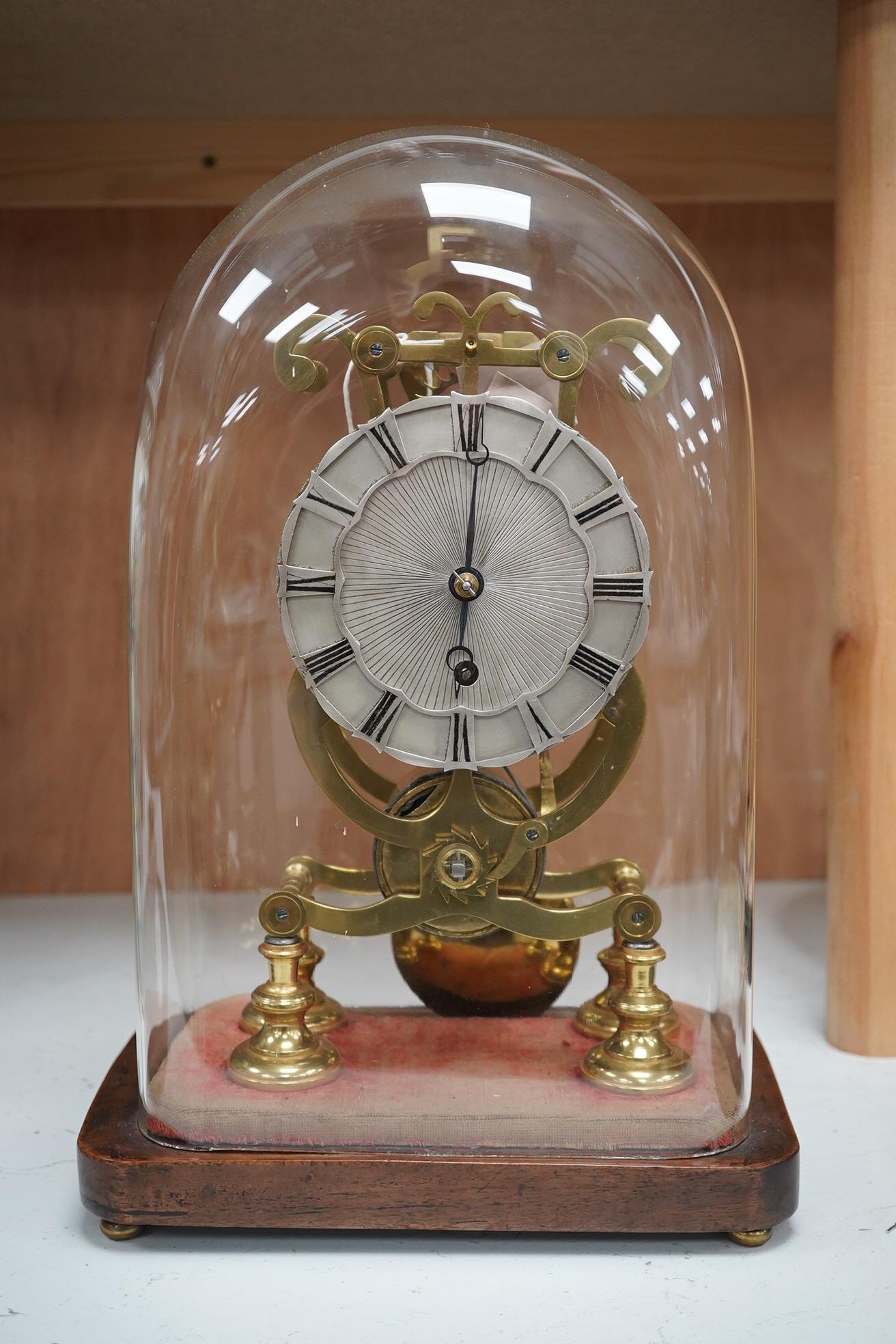 A late 19th century brass skeleton timepiece, the silvered chapter ring with Roman numerals, on a stand, under a glass dome, 37cm high. Condition - pendulum adjustment needed